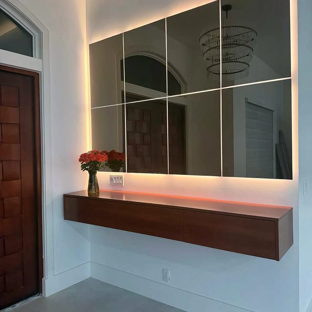 Foto real del recibidor con consola flotante en madera y espejos retroiluminados instalado por Custom Closet Florida, Florida, EE. UU.